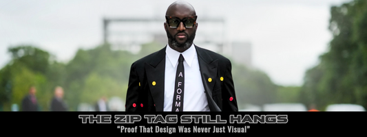 Virgil Abloh in a black suit with colorful buttons and “A FORMALITY” tie, with the caption “The Zip Tag Still Hangs – Proof That Design Was Never Just Visual.